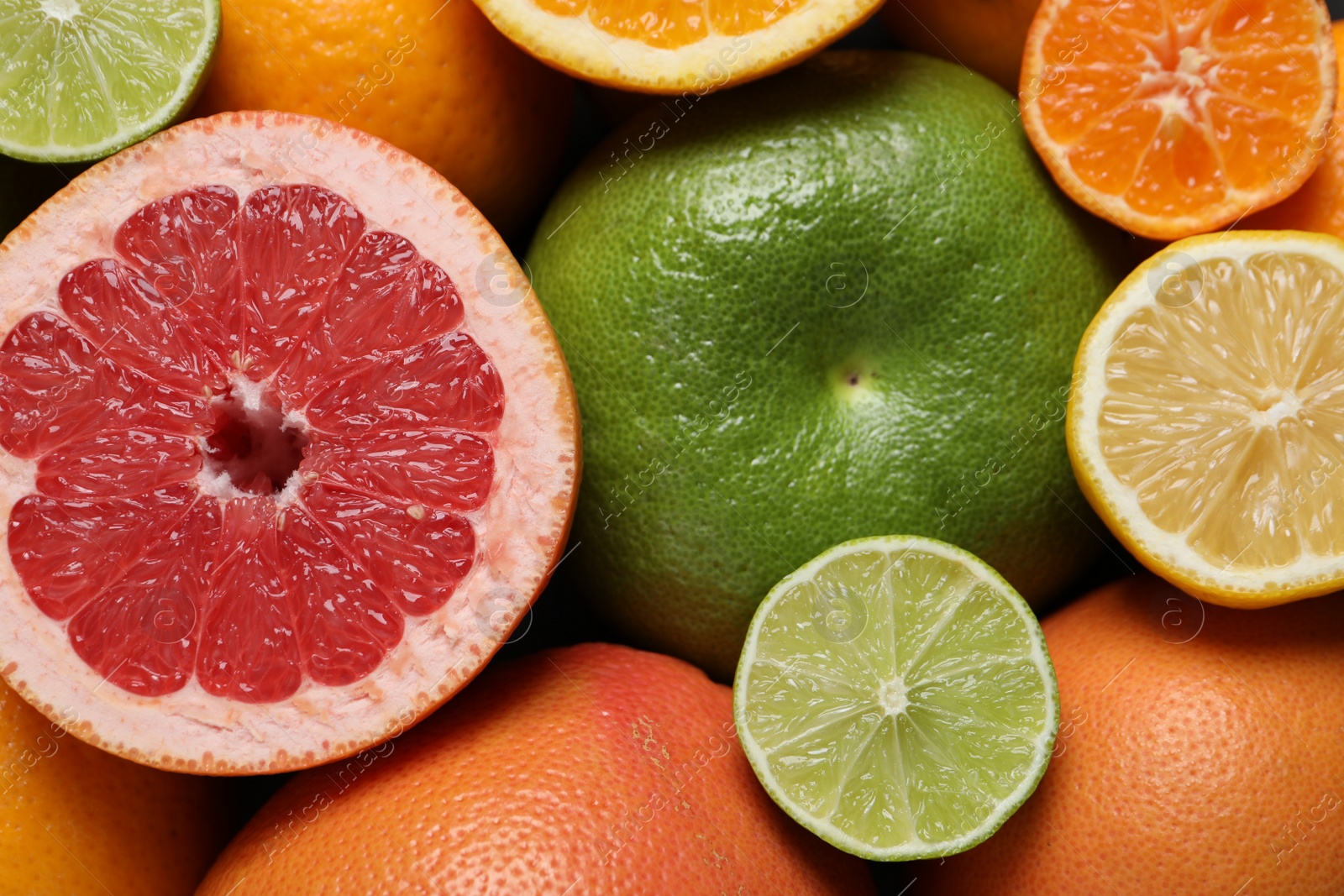 Photo of Different fresh whole and cut citrus fruits as background, top view