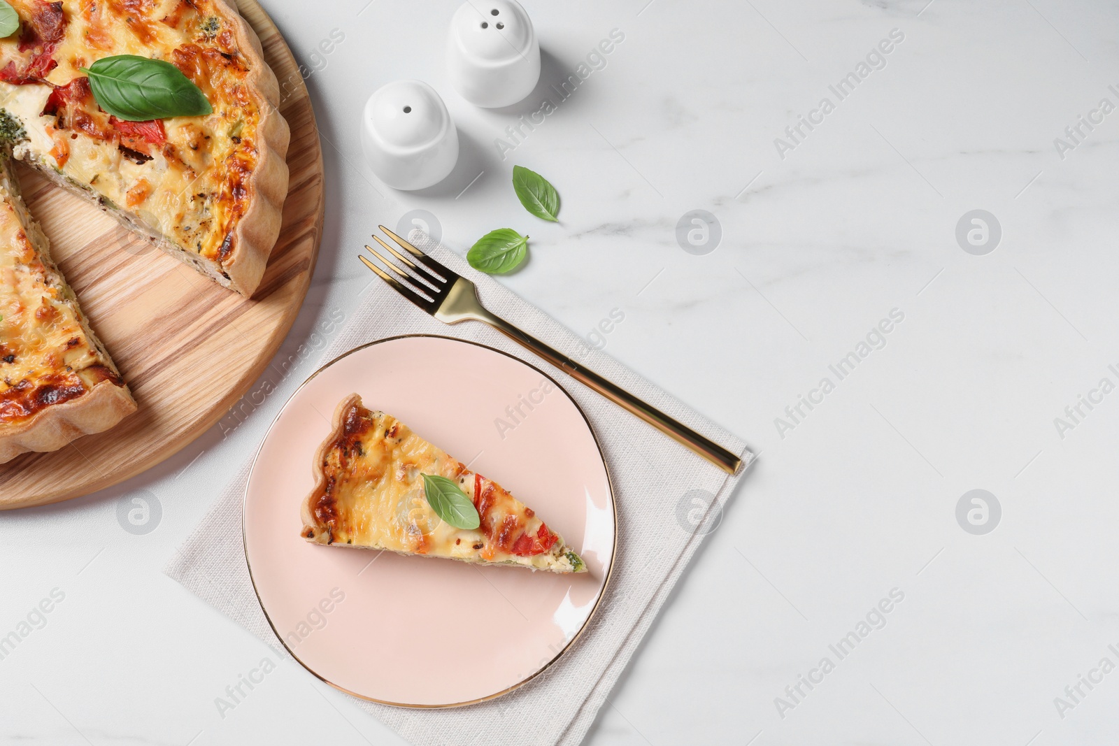 Photo of Tasty quiche with tomatoes, cheese and basil served on white marble table, flat lay. Space for text