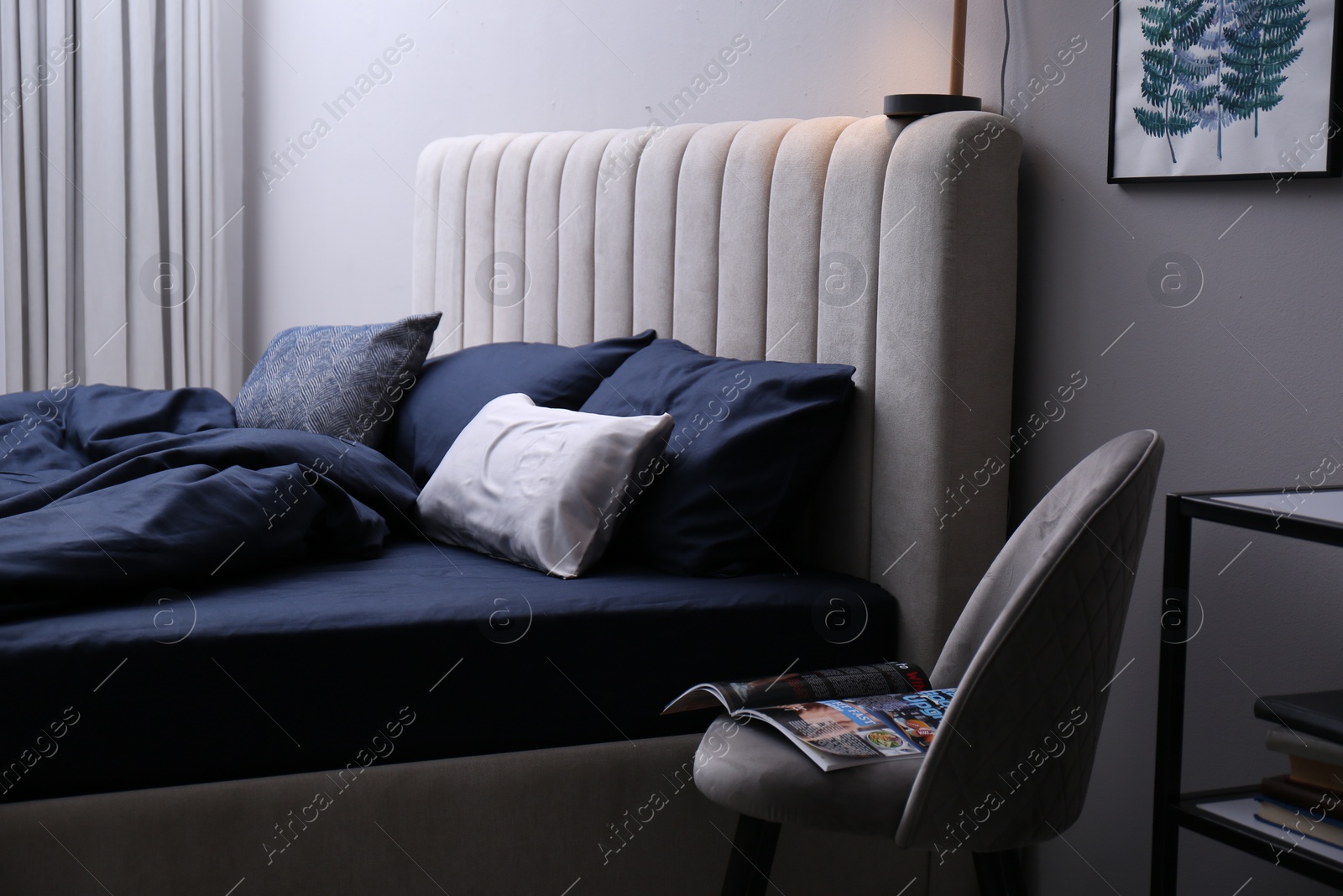 Photo of Bed with stylish silky linens in room