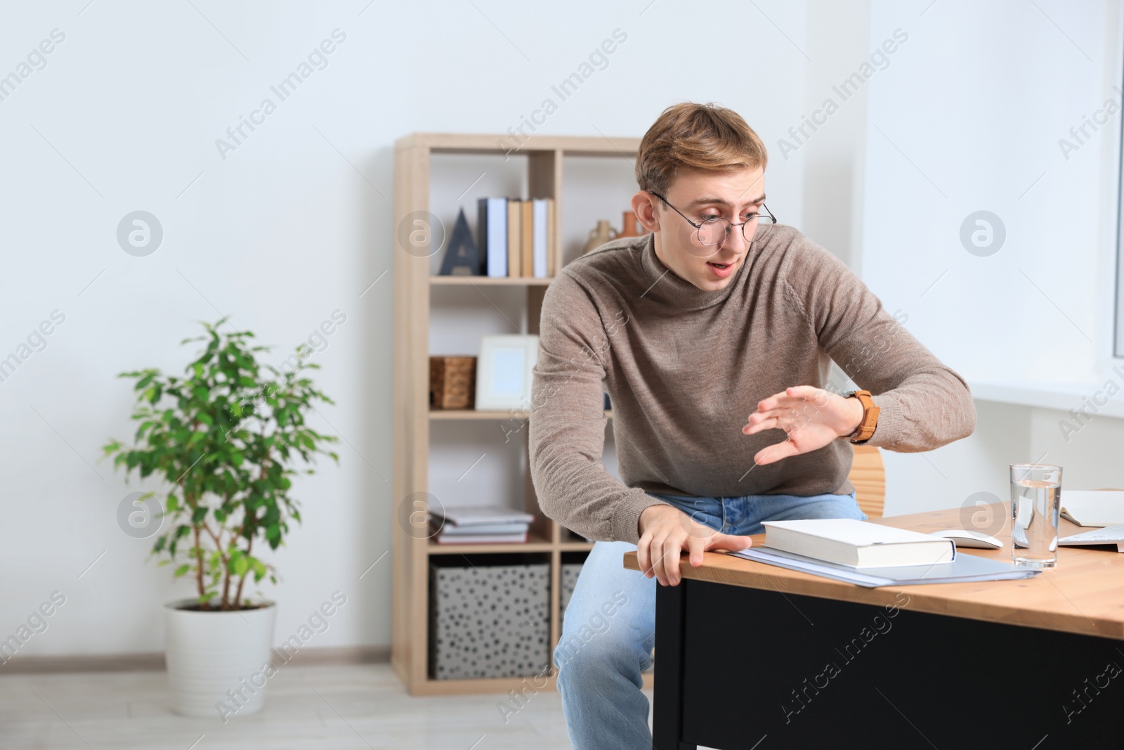 Photo of Emotional young man checking time in office, space for text. Being late