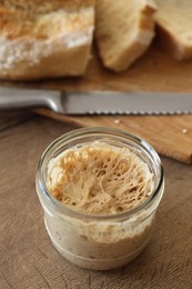 Sourdough starter in glass jar on wooden table