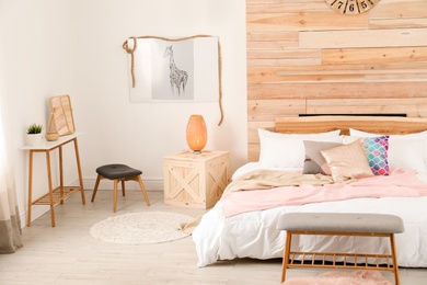 Photo of Stylish room interior with comfortable bed near wooden wall