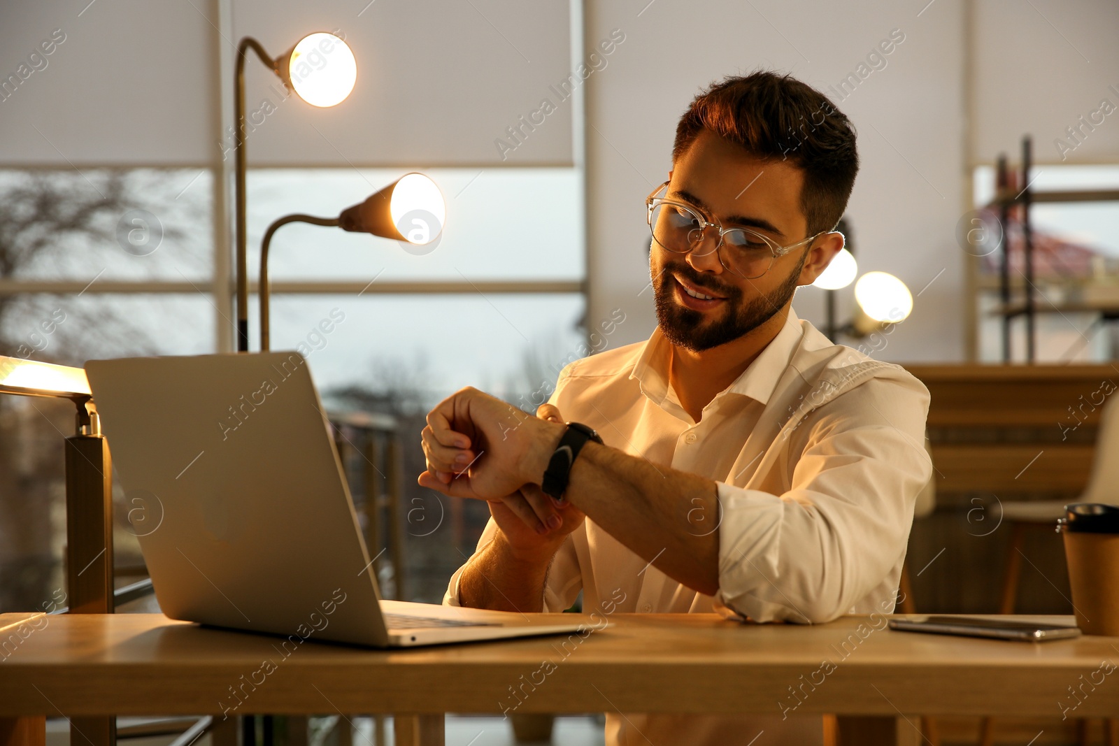 Photo of Man working with laptop at table in office