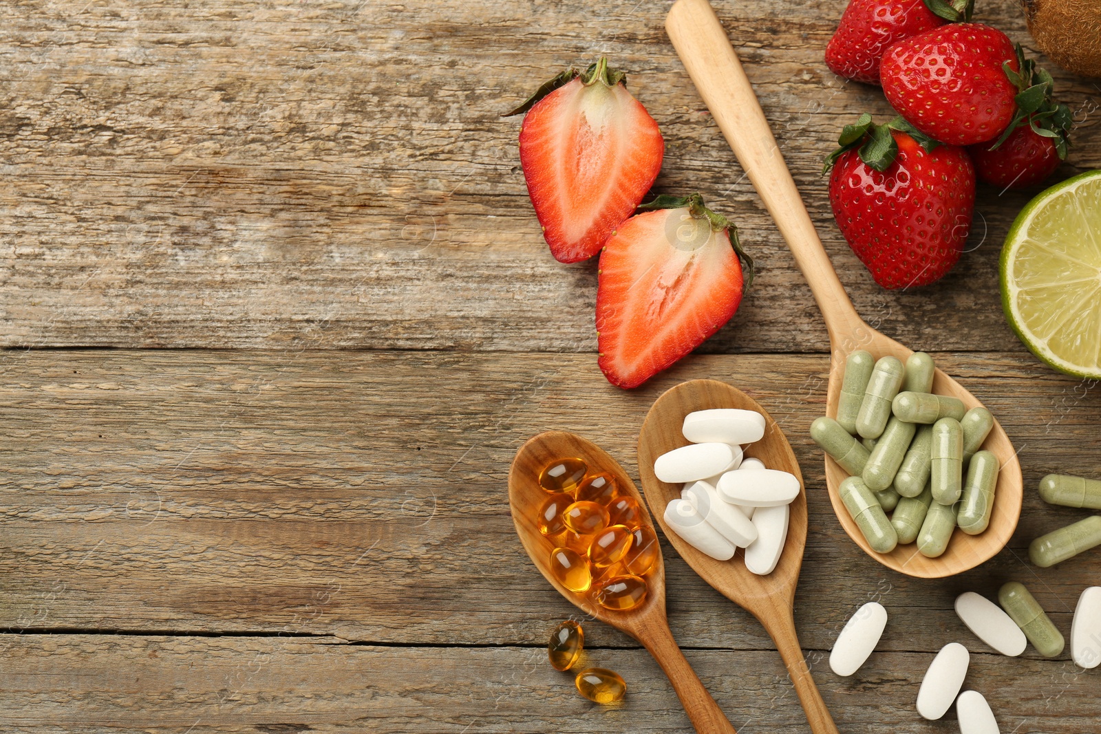 Photo of Different vitamin pills and fresh fruits on old wooden table, flat lay. Space for text