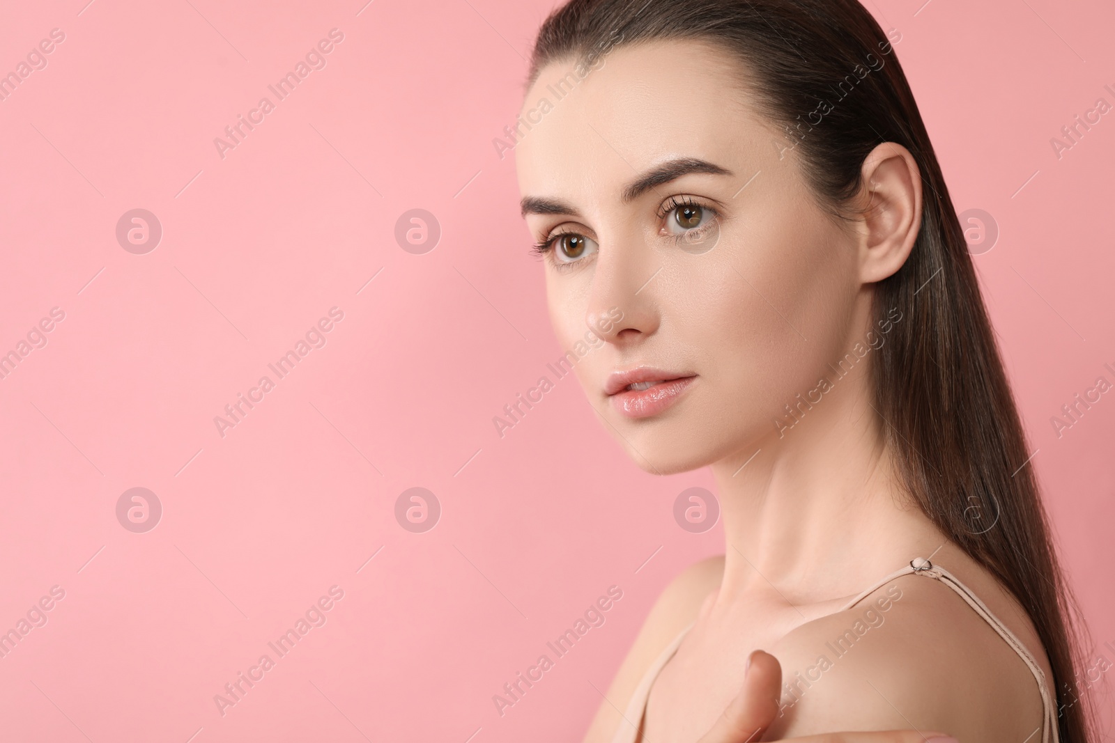 Photo of Portrait of beautiful young woman on pink background. Space for text