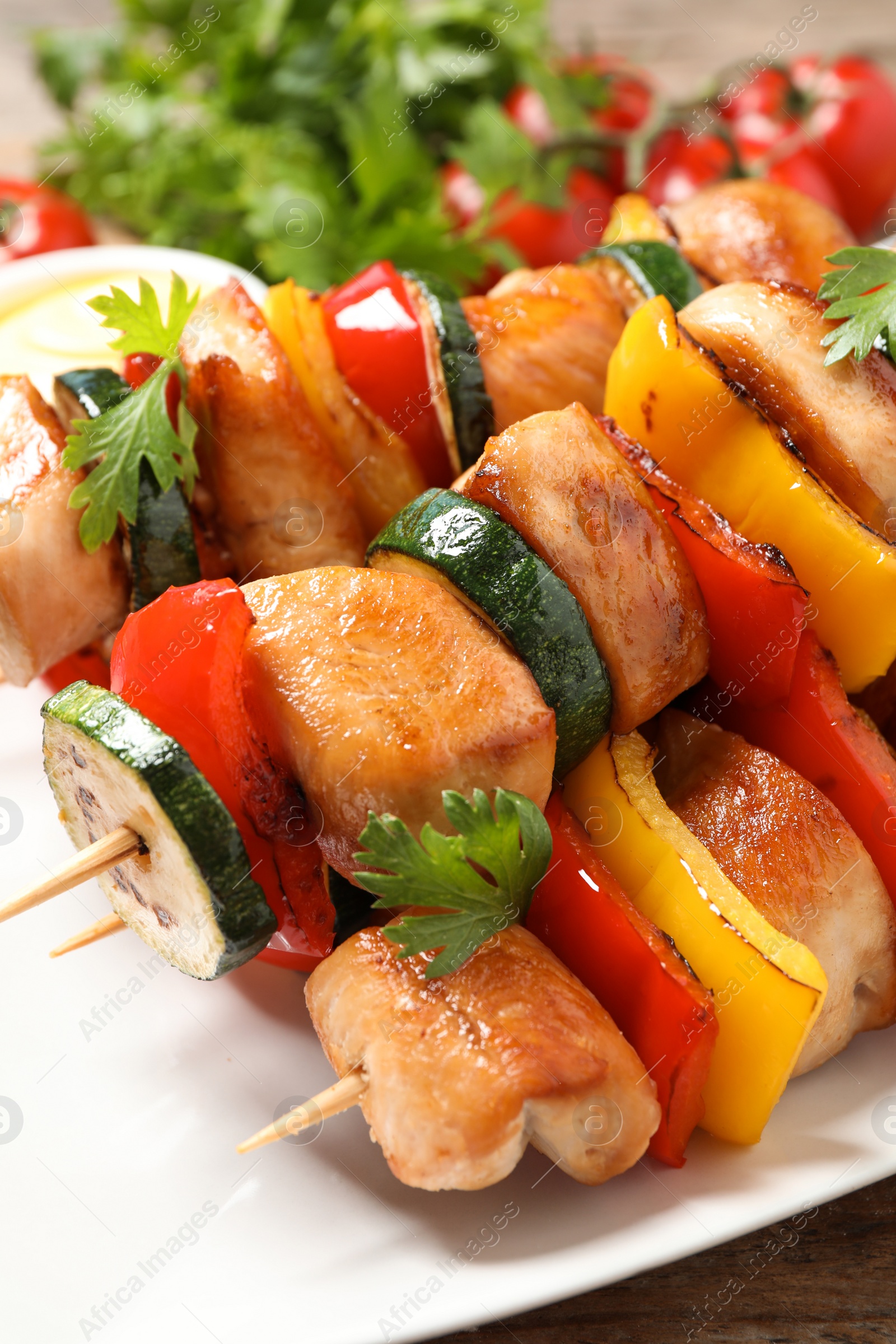 Photo of Delicious chicken shish kebabs with vegetables on table, closeup