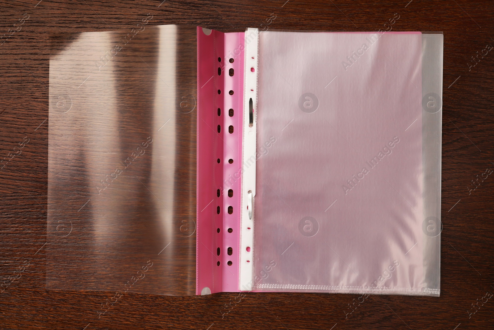 Photo of File folder with punched pockets on wooden table, top view