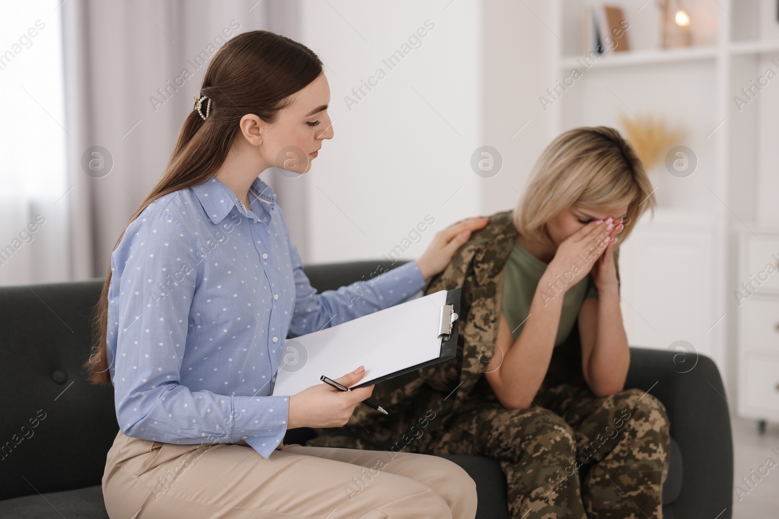 Photo of Psychotherapist working with military woman on sofa in office