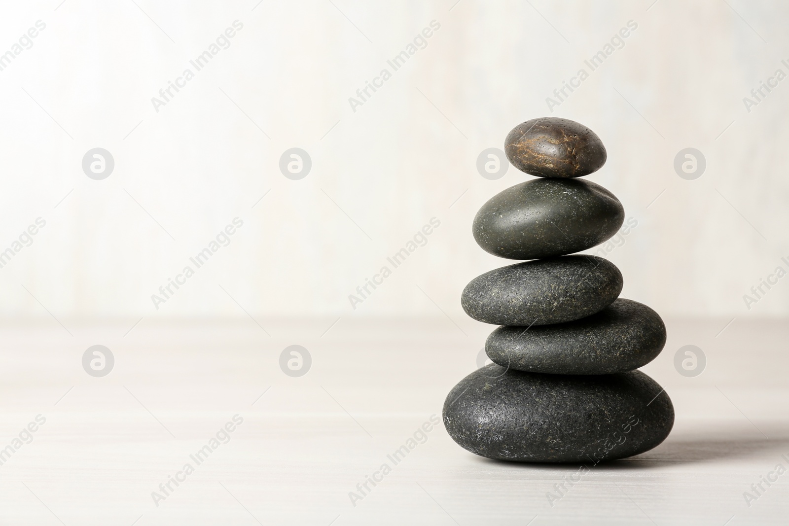 Photo of Stack of spa stones on table against white background, space for text