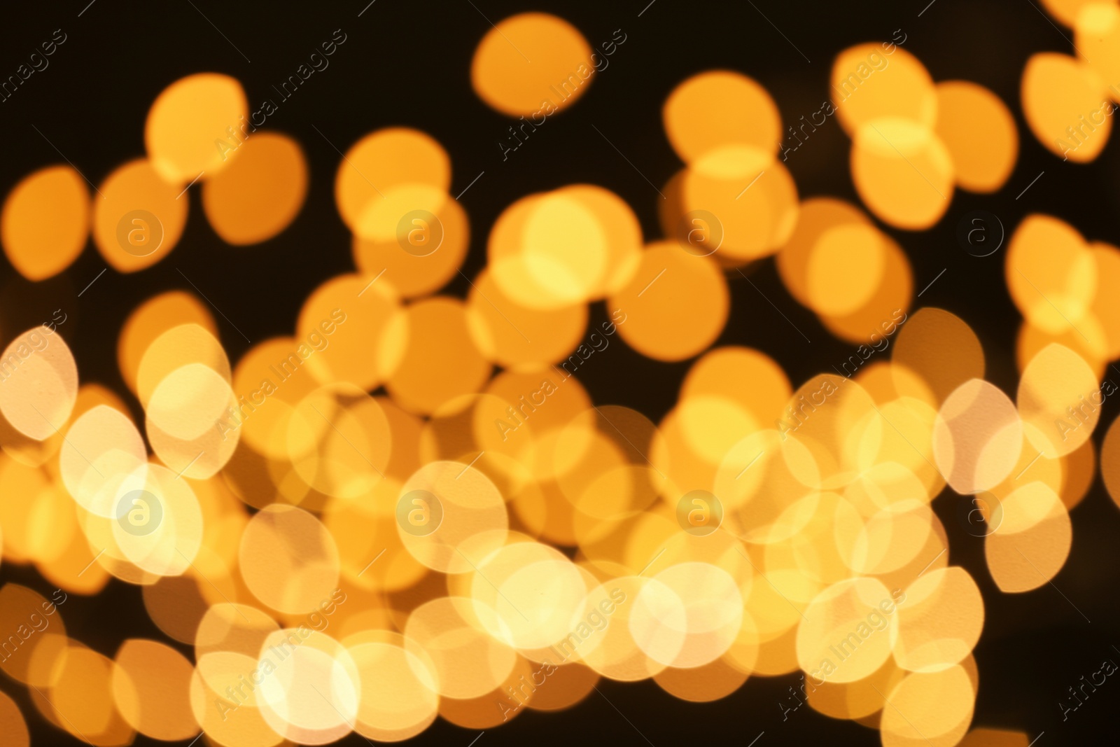 Photo of Beautiful golden lights on dark background. Bokeh effect