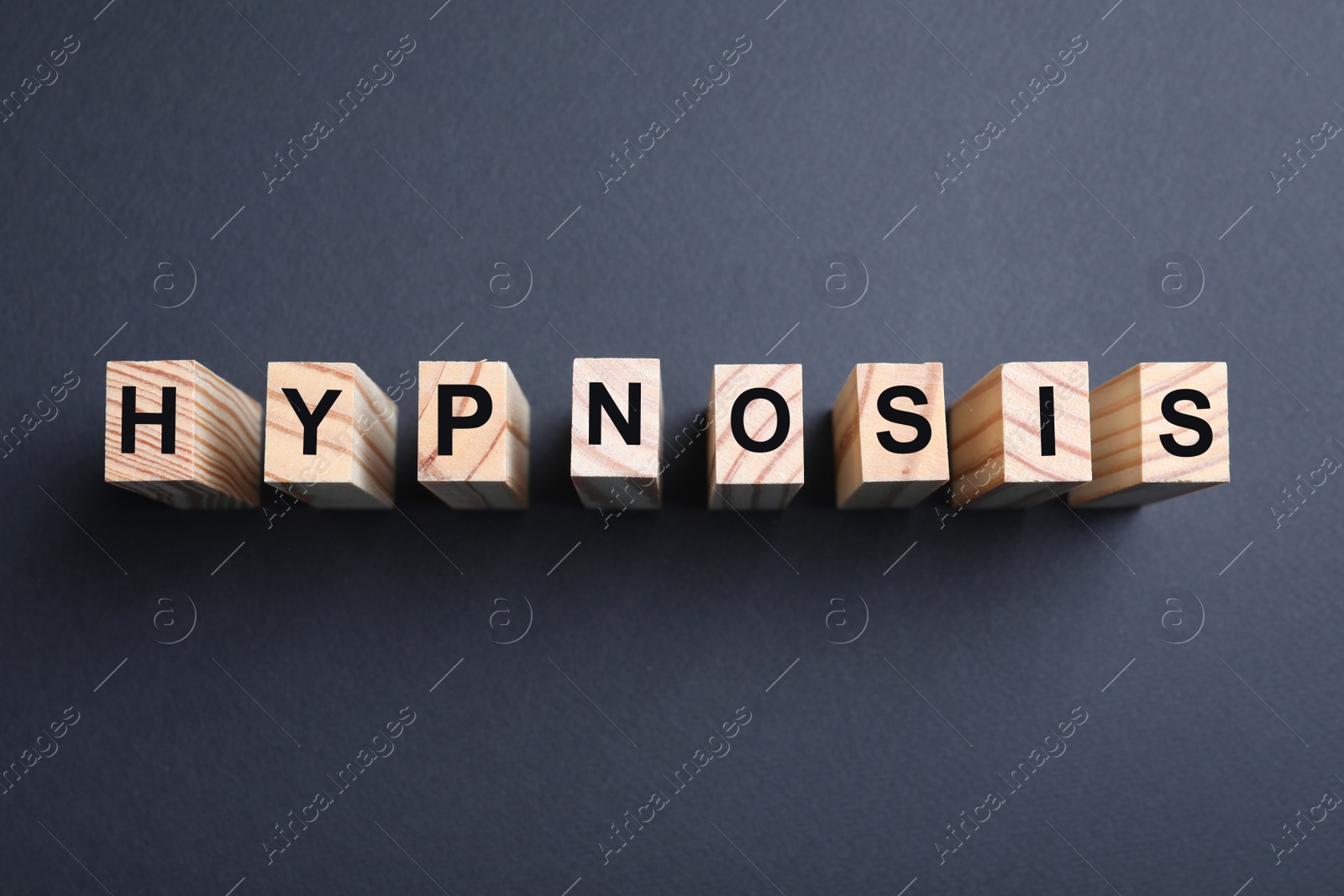 Photo of Wooden blocks with word HYPNOSIS on black background, flat lay