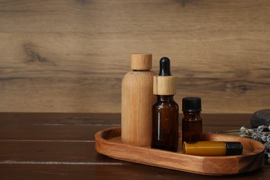 Photo of Aromatherapy products. Bottles of essential oil and lavender on wooden table, space for text