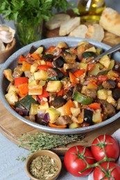 Photo of Delicious ratatouille and ingredients on table, closeup