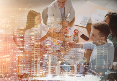 Image of Double exposure of team workers discussing questions in office and night cityscape                                                           