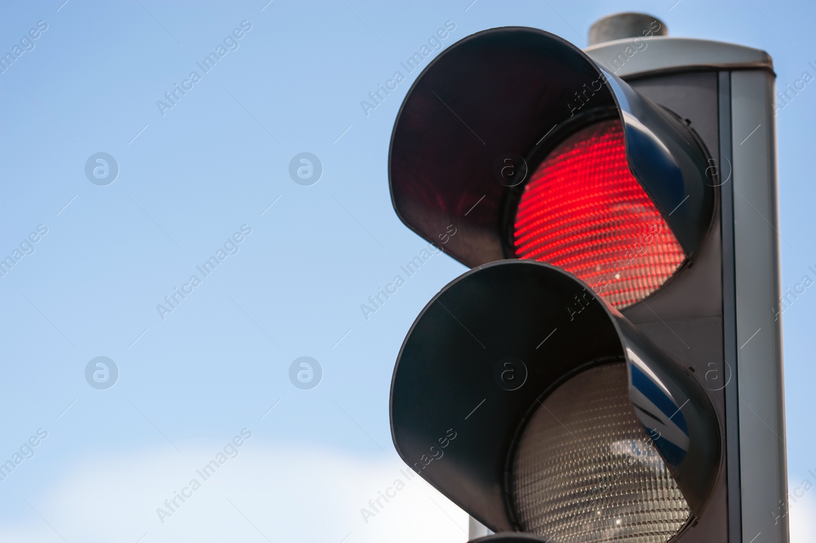 Photo of Traffic light against blue sky, closeup. Space for text