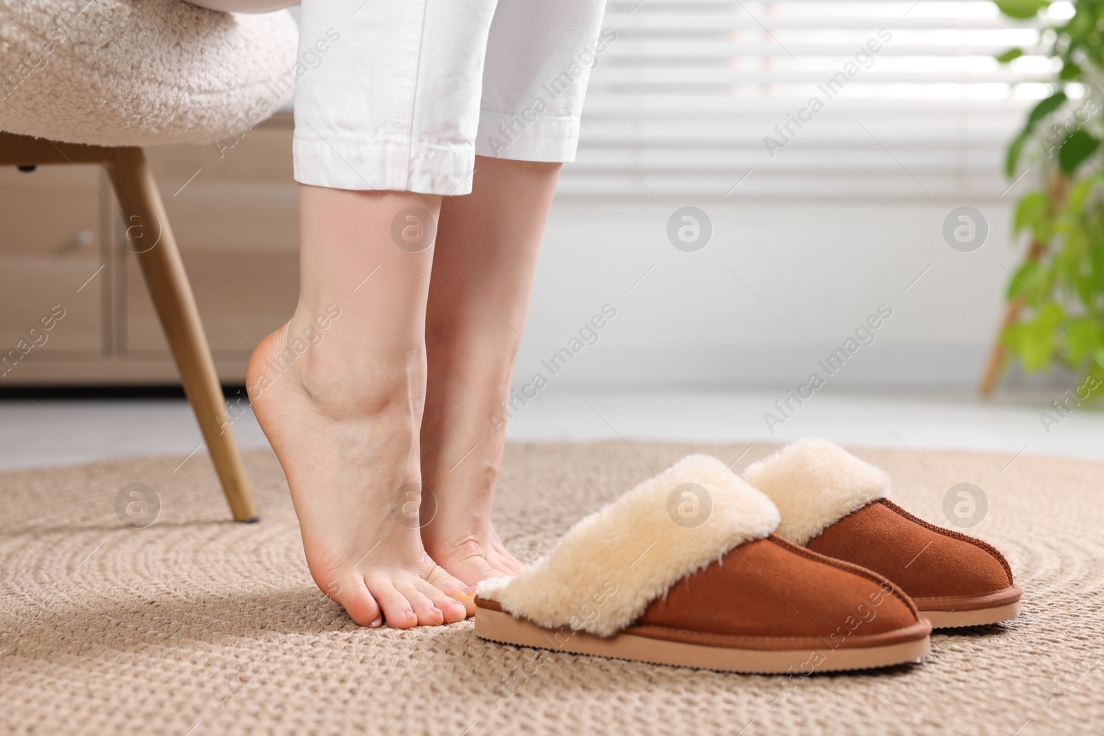 Photo of Woman near soft slippers at home, closeup