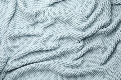 Soft light blue knitted plaid as background, top view