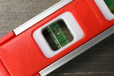 Photo of Red building level on wooden table, top view