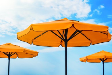Image of Beautiful orange beach umbrellas against blue sky