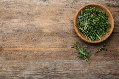 Photo of Fresh rosemary on wooden table, flat lay. Space for text