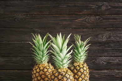 Photo of Fresh pineapples on wooden background