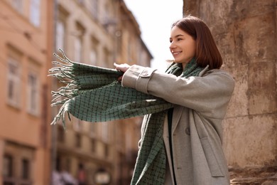 Beautiful woman in warm scarf on city street