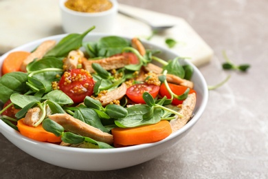 Delicious fresh chicken salad served on grey table, closeup