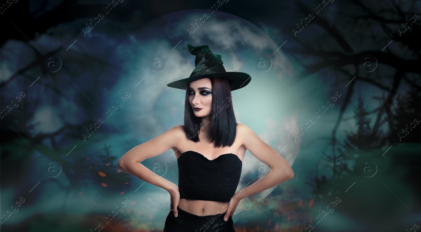 Image of Young girl dressed as witch in misty forest on full moon night. Halloween fantasy