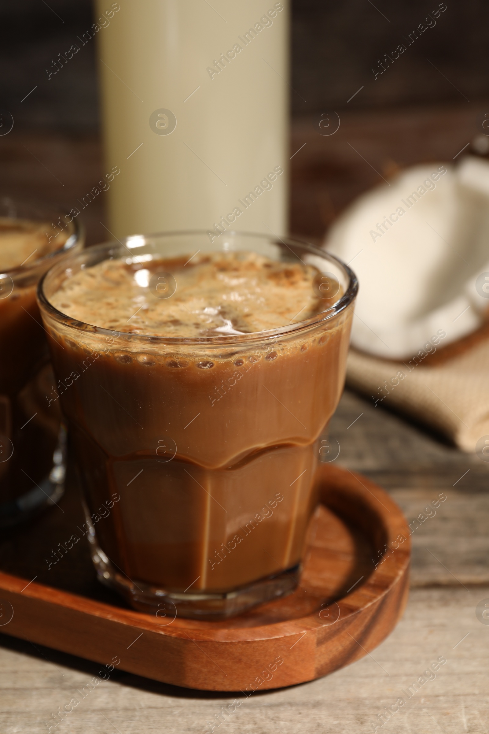 Photo of Glass of tasty coffee on wooden table, closeup