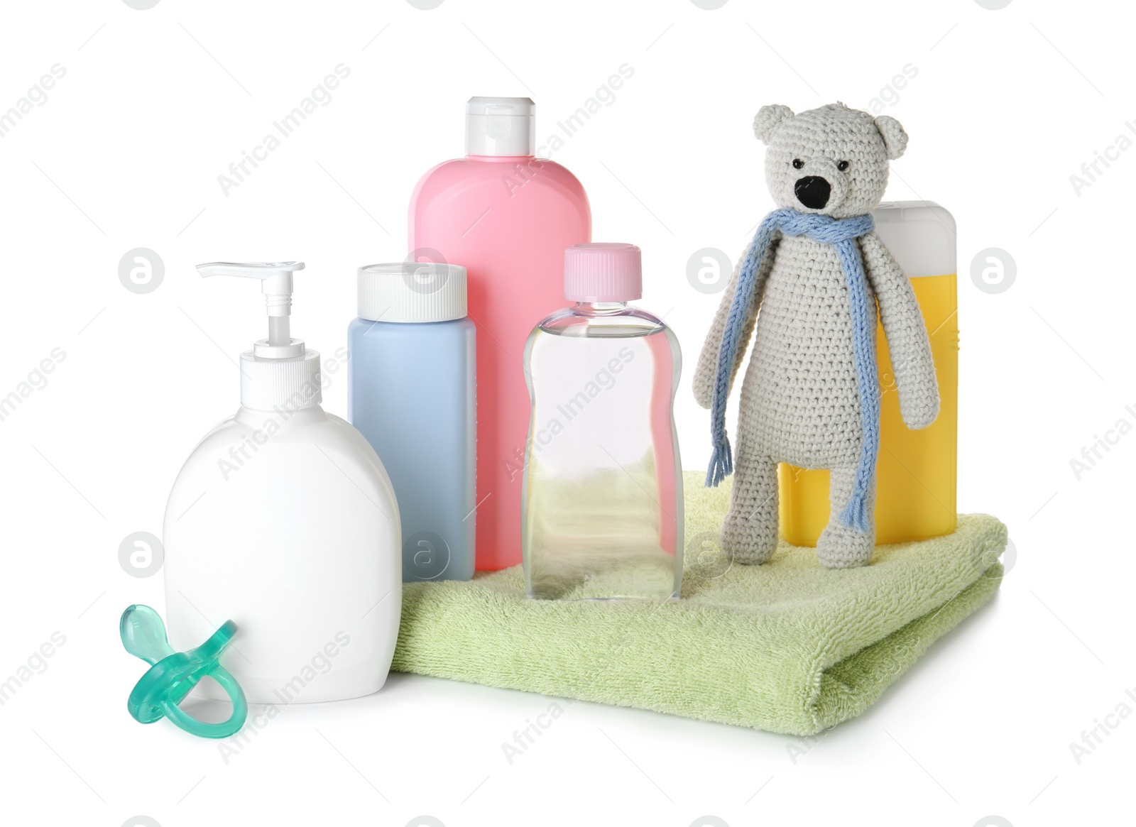 Photo of Bottles of baby cosmetic products, towel, pacifier and toy bear on white background