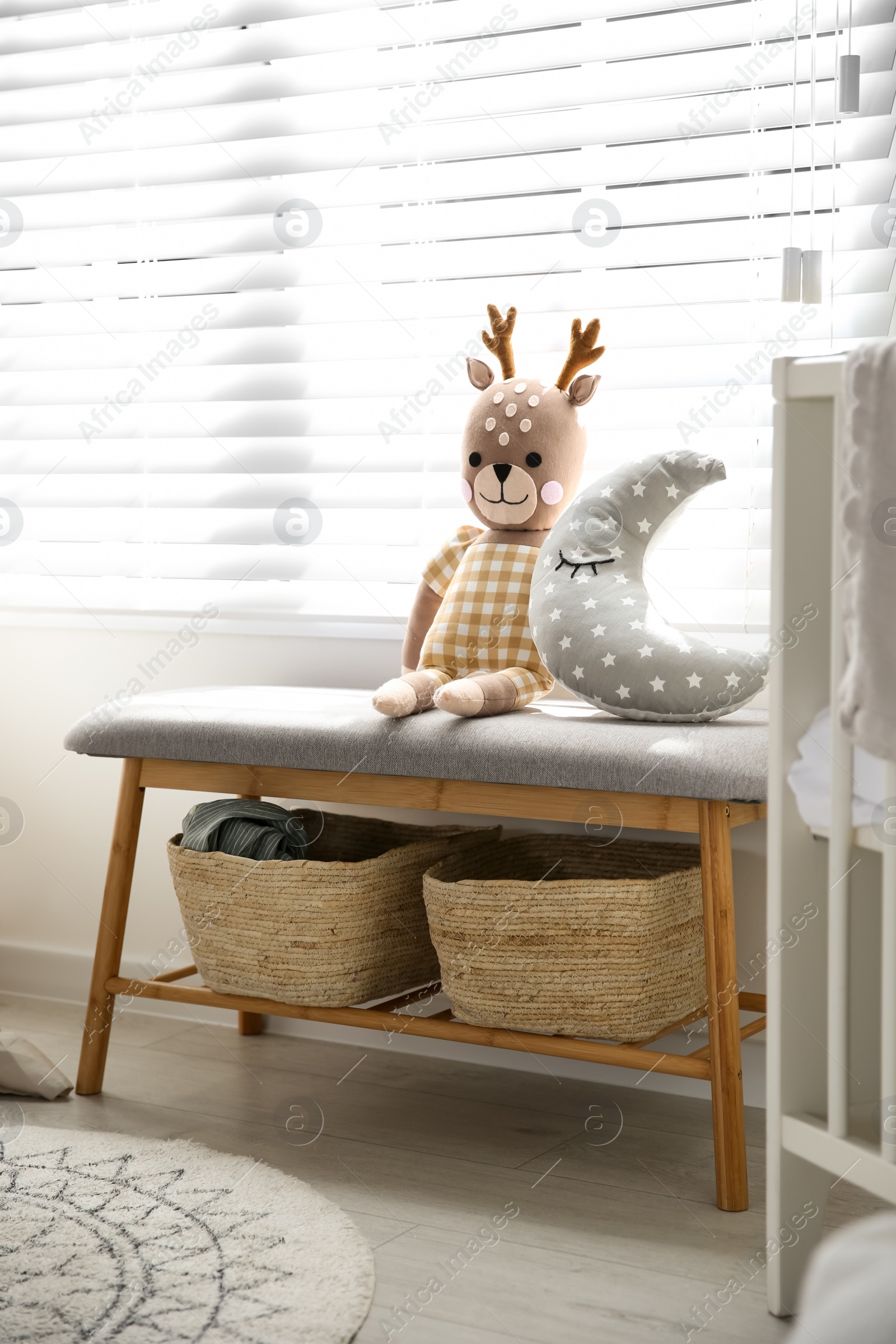 Photo of Bench with toys near window in baby room. Interior design