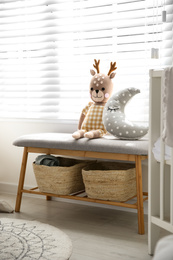 Photo of Bench with toys near window in baby room. Interior design