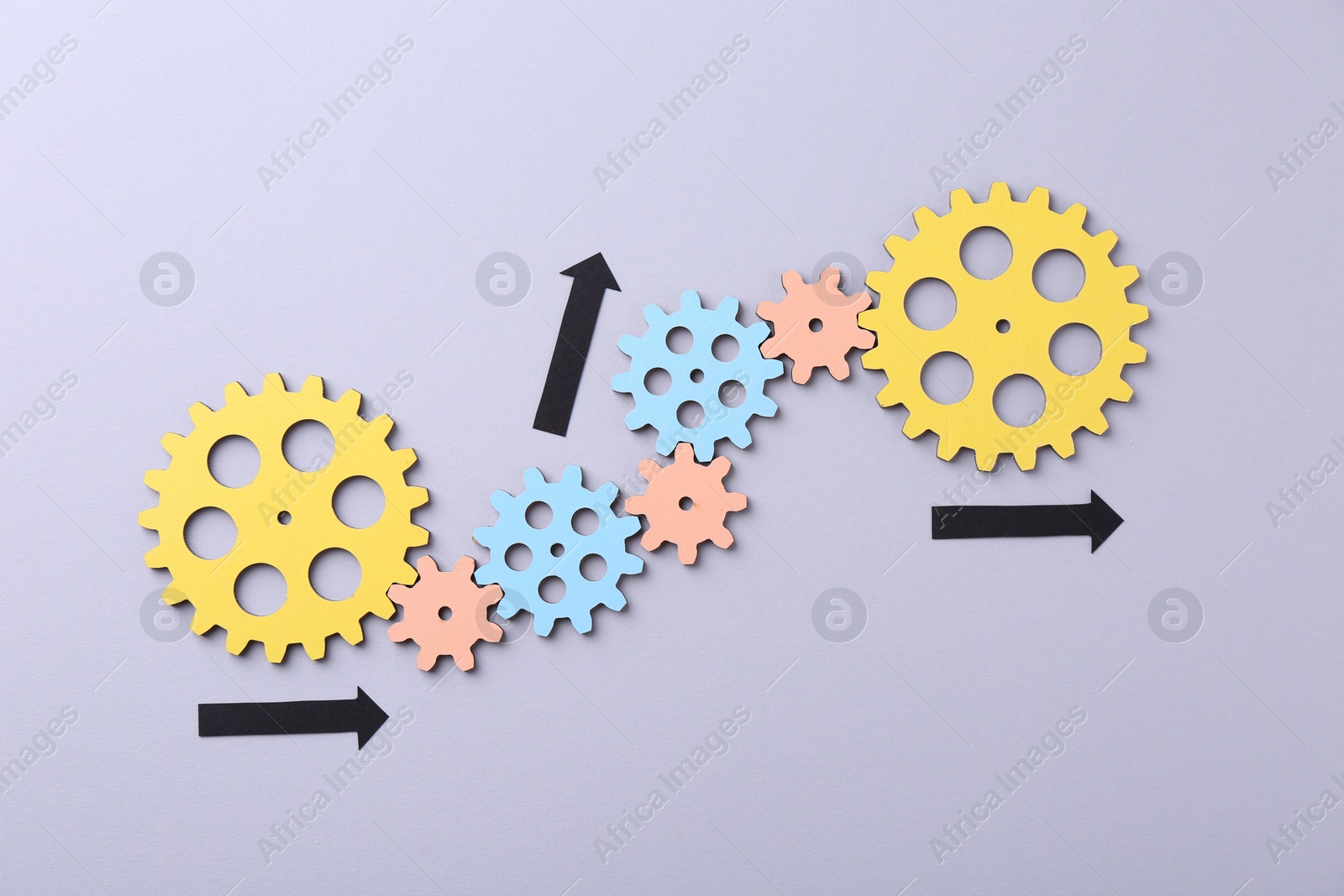 Photo of Business process organization and optimization. Scheme with wooden figures and arrows on lilac background, top view