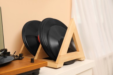 Photo of Vinyl records and player on white wooden table indoors