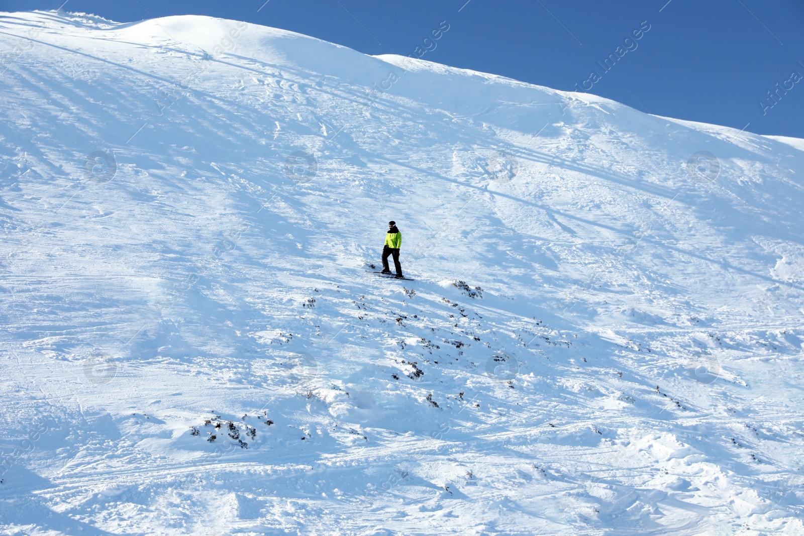 Photo of Male skier on slope at resort. Winter vacation