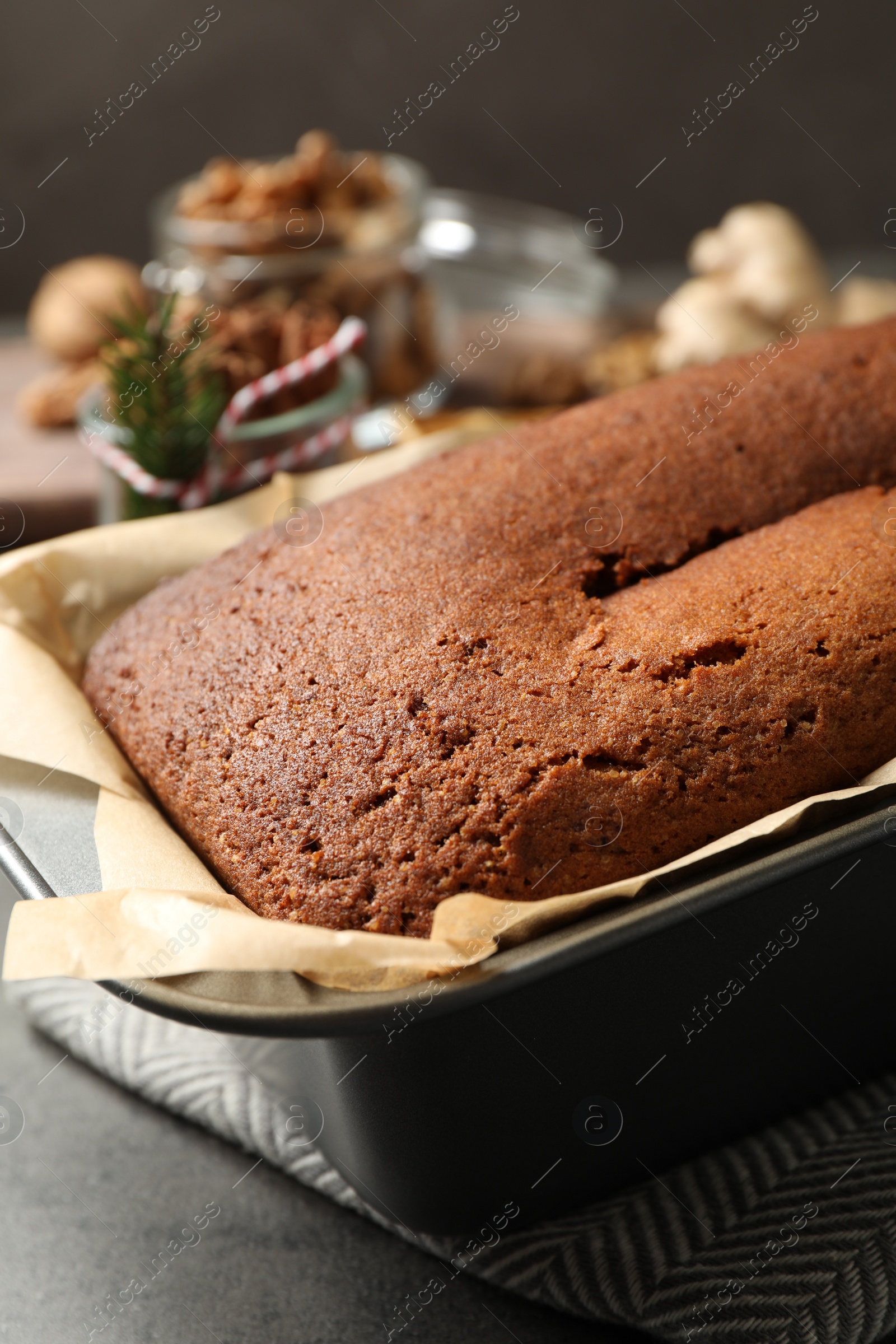 Photo of Delicious gingerbread cake in baking dish on grey table, closeup