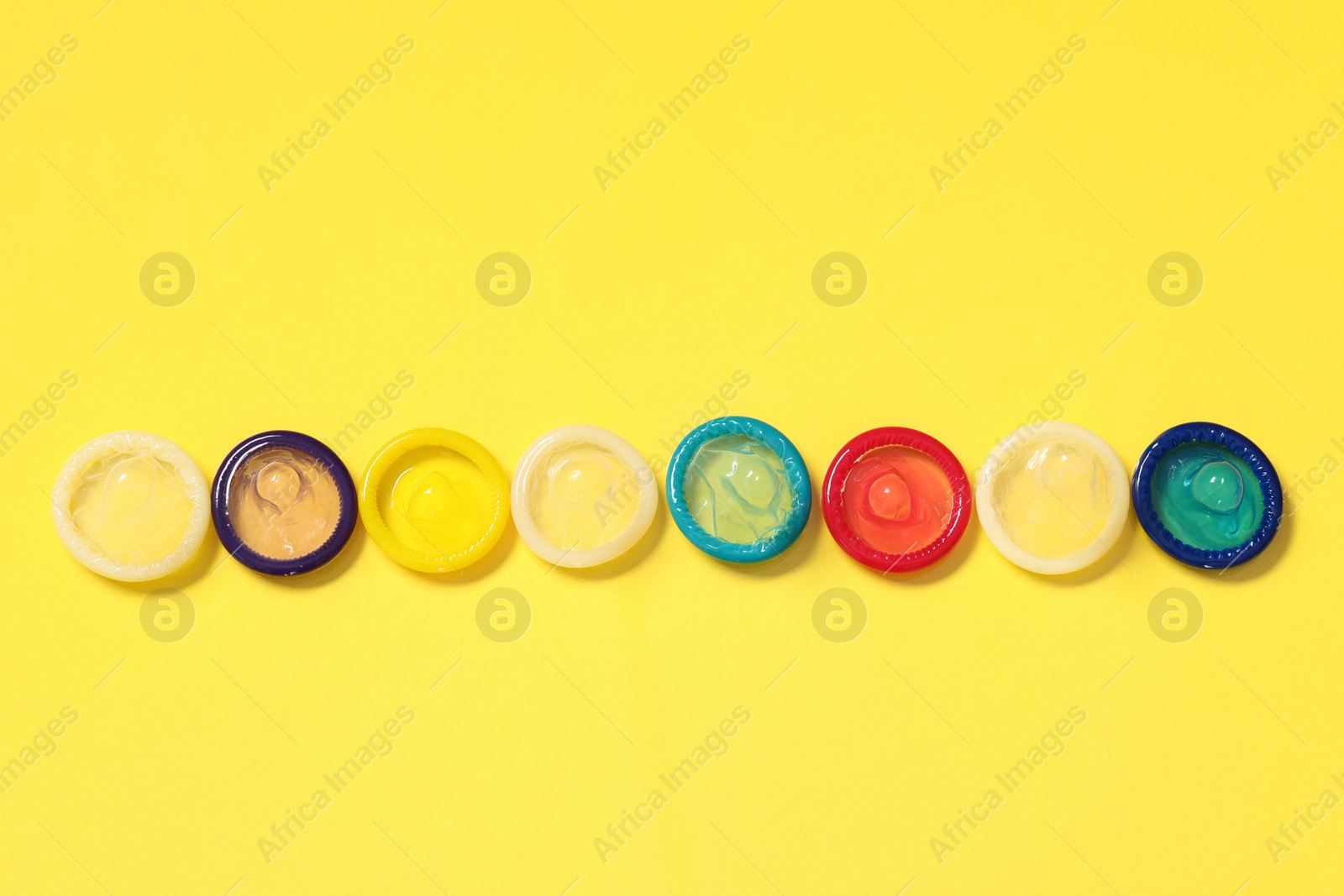 Photo of Condoms on yellow background, top view. Safe sex