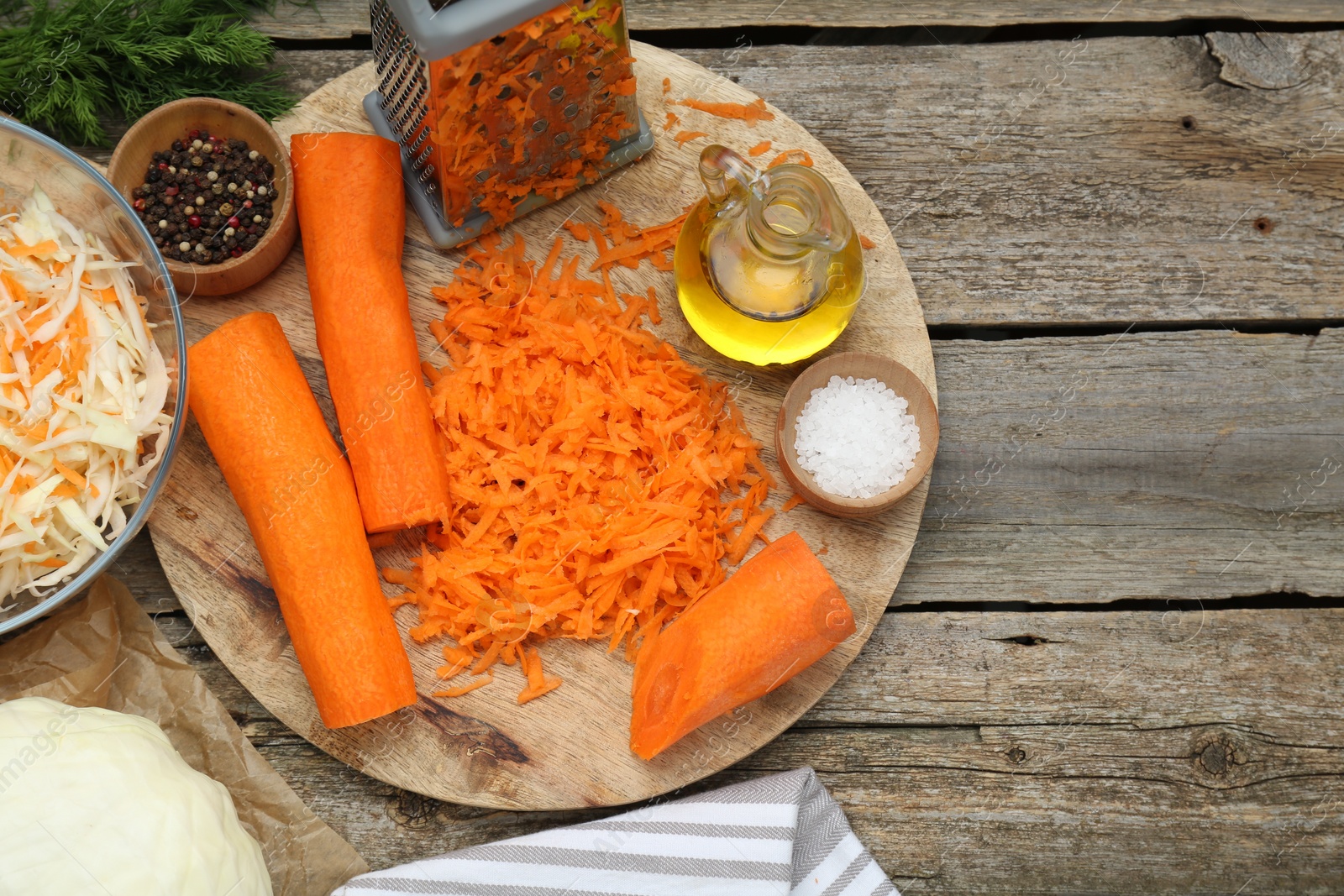 Photo of Cooking delicious sauerkraut soup. Fresh chopped carrot and ingredients on old wooden table, flat lay. Space for text