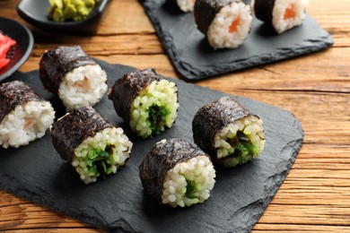 Photo of Tasty sushi rolls served on wooden table