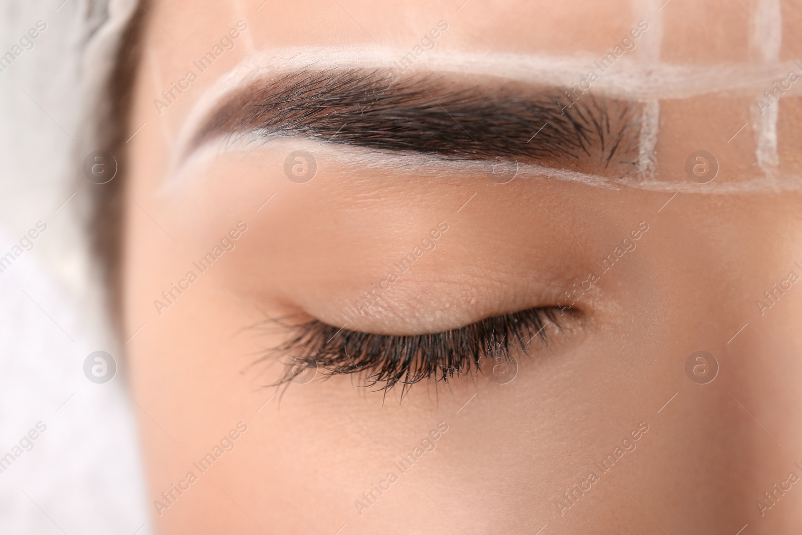 Photo of Young woman with marks on face before eyebrow permanent makeup procedure, closeup