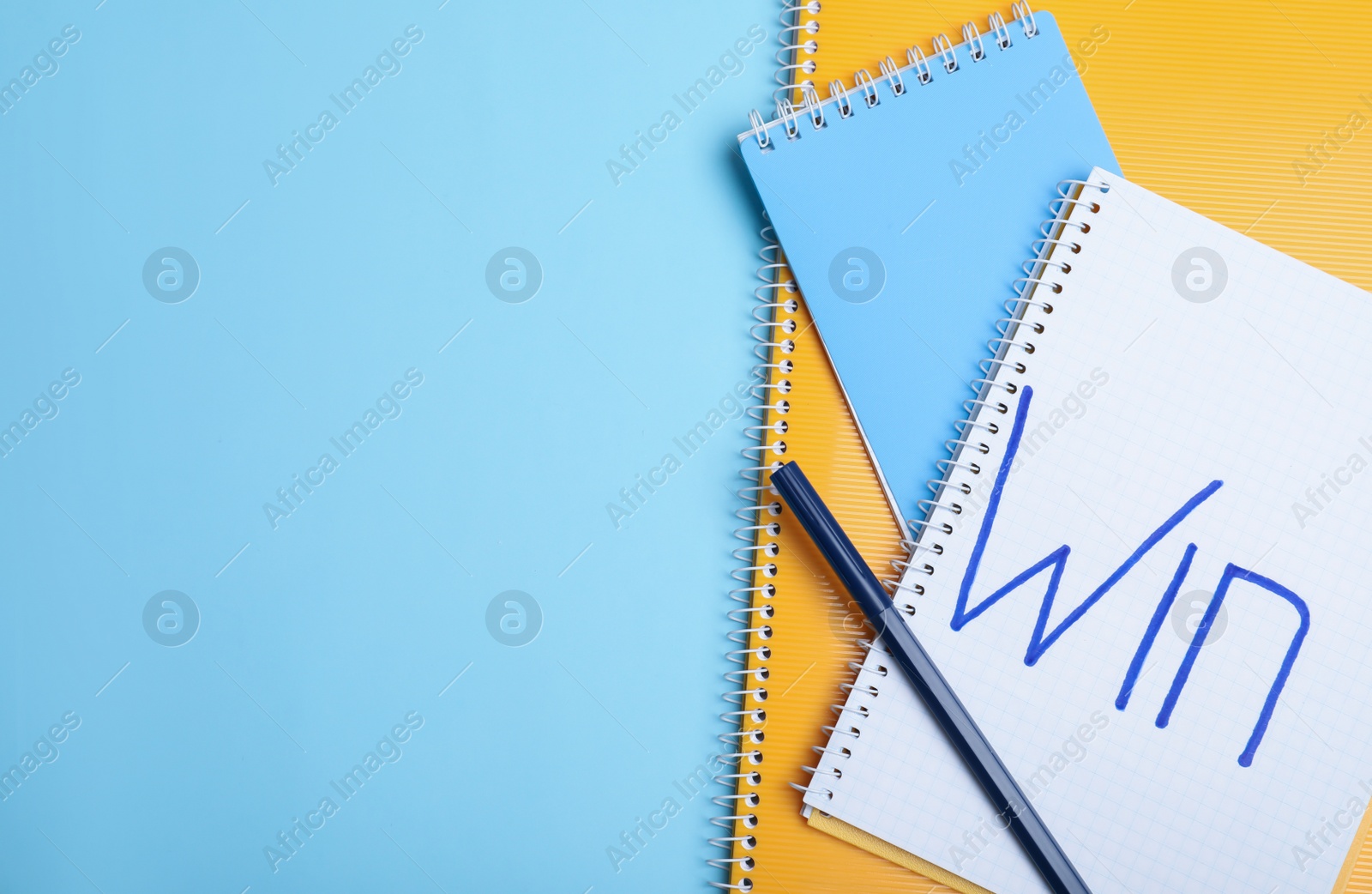 Photo of Flat lay composition of notebooks with word Win and space for text on color background. Victory concept