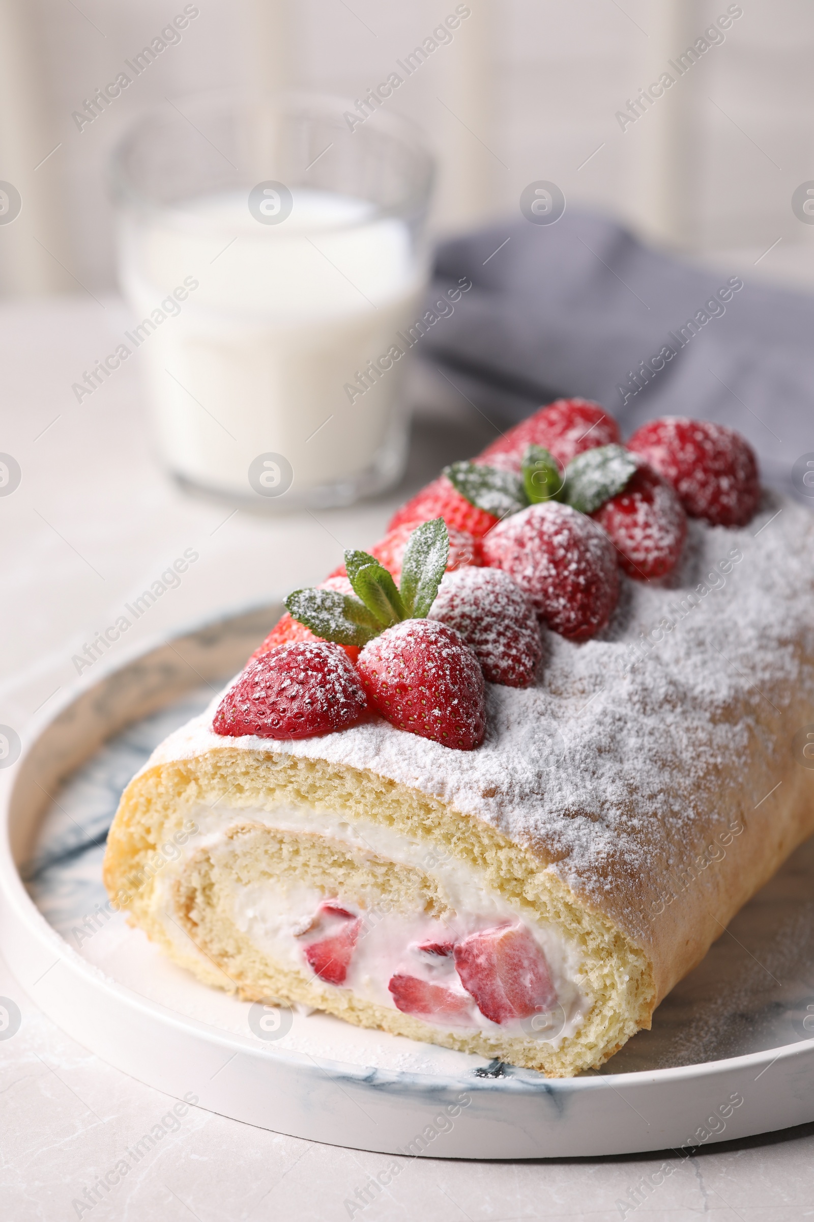 Photo of Delicious cake roll with strawberries and cream on light gray table