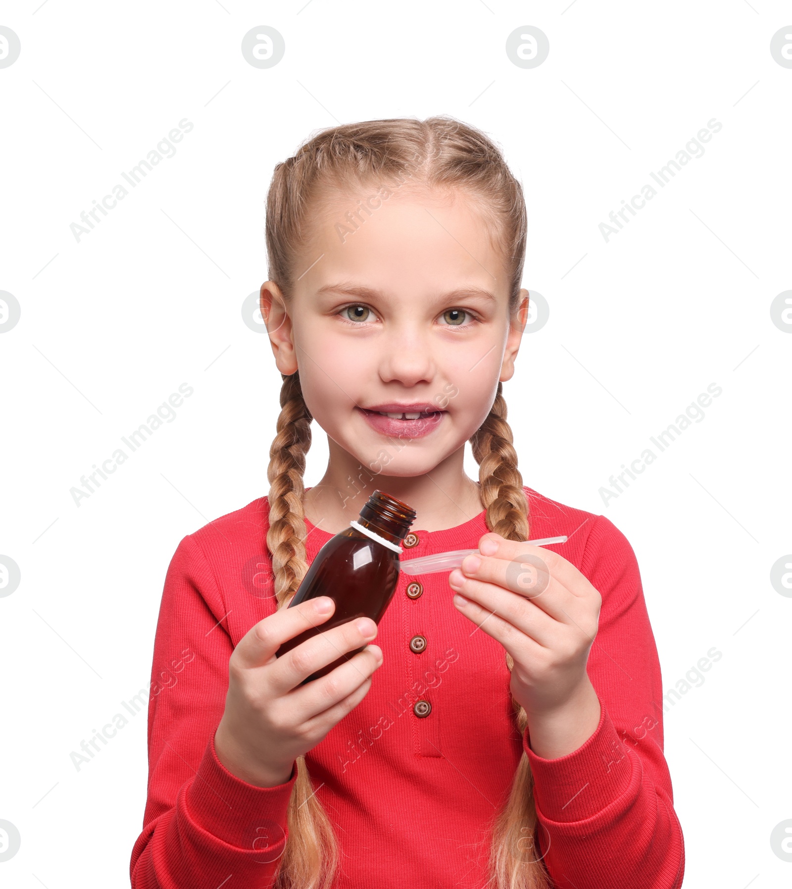 Photo of Cute girl pouring syrup from bottle into dosing spoon on white background