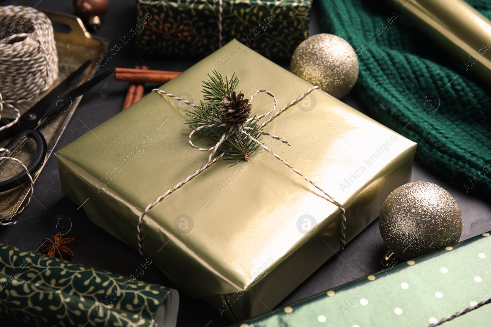 Photo of Composition with beautifully wrapped gift box on black table