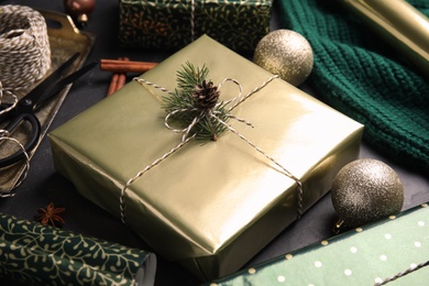 Photo of Composition with beautifully wrapped gift box on black table