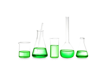Photo of Different laboratory glassware with light green liquid isolated on white