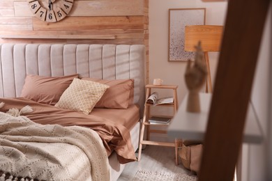 Bed with stylish linen and soft pillows in room