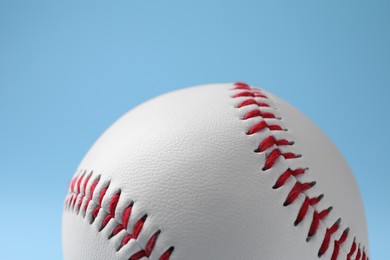 One baseball ball on light blue background, closeup