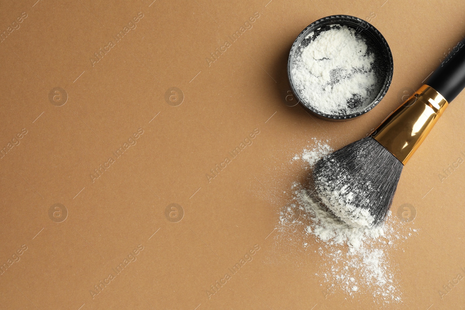 Photo of Rice loose face powder and makeup brush on brown background, flat lay. Space for text