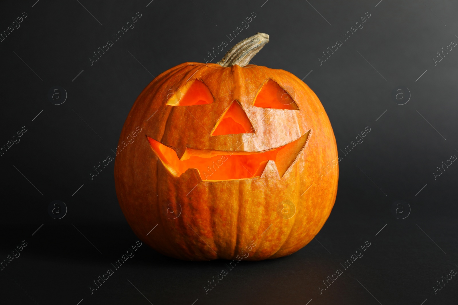 Photo of Halloween pumpkin head jack lantern on dark background